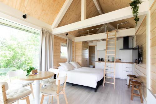 a room with a bed and a table and a kitchen at Tiny house - optioneel met hottub in Dokkum