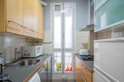 a kitchen with a sink and a refrigerator at 2 bedrooms 1 bathroom furnished - Anton Martin - Vintage - MintyStay in Madrid