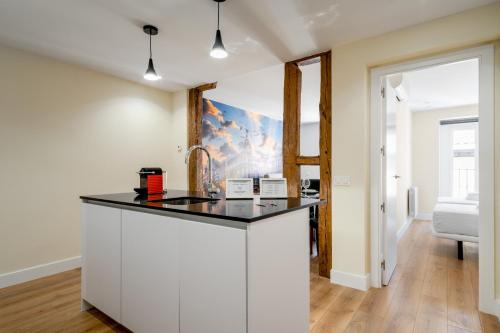 una cocina con una isla blanca en una habitación en 2 bedrooms 2 bathrooms furnished - Malasaña - bright and refurbished - MintyStay en Madrid