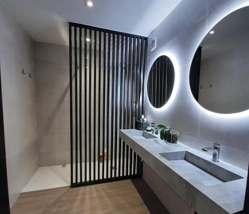 a bathroom with two sinks and a large mirror at Vila Nikau - Garden by the Sea in Lagoa