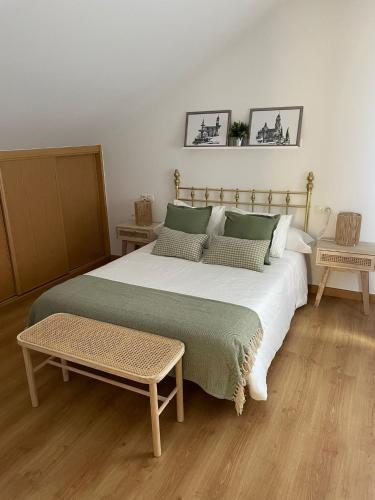 a bedroom with a large bed and two tables at O Pequeno Rincón in Allariz