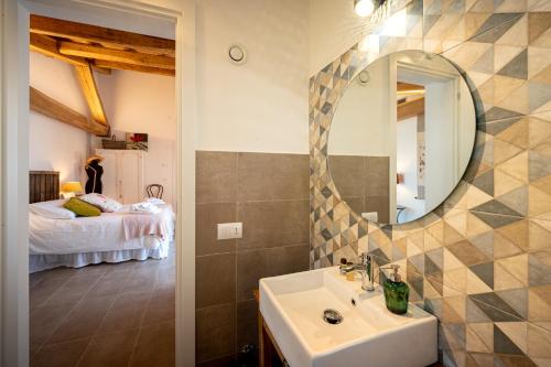 a bathroom with a sink and a mirror and a bed at Sorelle Biologiche in Monte Castello di Vibio