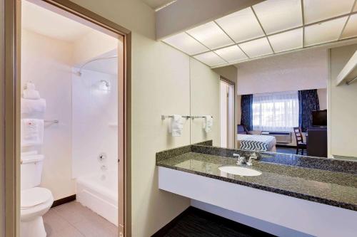 a bathroom with a sink and a toilet and a mirror at Travelodge by Wyndham Aberdeen in Aberdeen