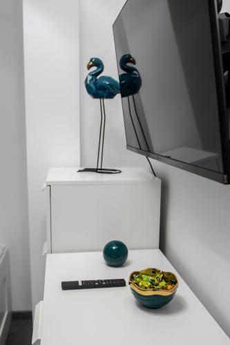 a table with a mirror and two blue birds on it at Apartamenty ASLux - Noclegi Energylandia Zator in Zator
