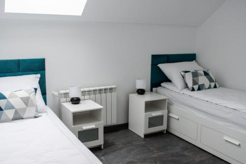 a bedroom with two beds and two night stands at Apartamenty ASLux - Noclegi Energylandia Zator in Zator