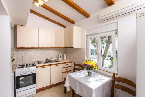 una cucina con tavolo e vaso di fiori di Apartment Nadalina a Dubrovnik