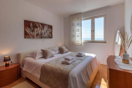 a bedroom with a bed with two towels on it at SEA VIEW- spacious apartment with shared pool in Split