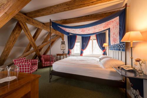 a bedroom with a canopy bed with a window at Hotel & Restaurant Alte Rheinmühle in Busingen am Hochrhein