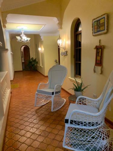 a living room with two chairs and a chandelier at El Castillo Tropical in Cabrera