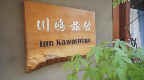 un cartello sul lato di un edificio con una pianta di Inn Kawashima a Kyoto