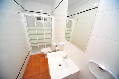 ein weißes Bad mit einem Waschbecken und einem WC in der Unterkunft Orange Park Duplex Familiar Jardin in Benicàssim