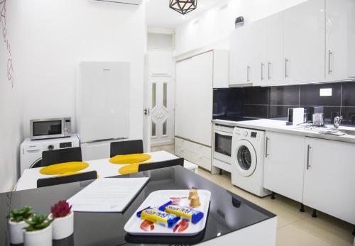 a kitchen with white cabinets and a table with food on it at OAZU downtown flat in Budapest