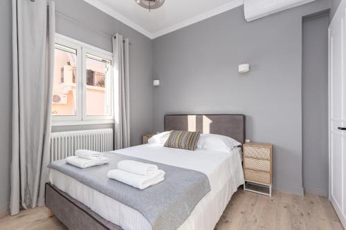 a white bedroom with a bed with towels on it at House Anna Maria in Mantoúkion