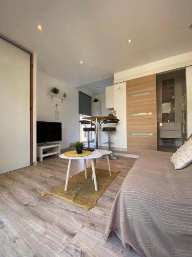 Un dormitorio con una cama y una mesa. en Studio proche de la plage de l'almanarre en Hyères