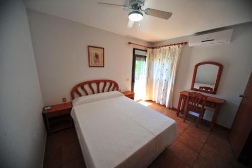 1 dormitorio con cama, escritorio y espejo en Orange Park Duplex Atico Vista Piscina en Benicàssim