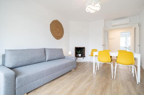 ラ・ピネーダにあるHauzify I Apartament Solpinsのソファとテーブルと椅子のあるリビングルーム