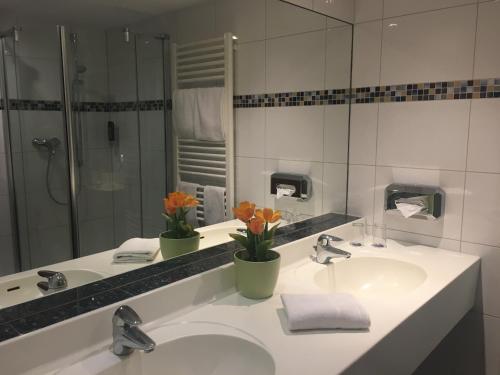 a bathroom with two sinks and a large mirror at Alexander am Zoo in Frankfurt/Main