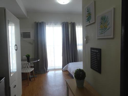 a room with a bedroom with a bed and a window at SoSe's Crib at Mesaverte Garden Residences in Cagayan de Oro