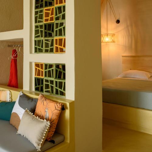 a bedroom with a bed and a bench with pillows at Sublime Villa & Caves in Akrotiri