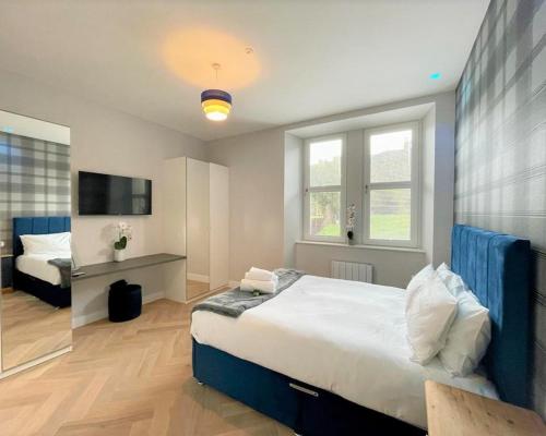 a bedroom with a large bed and a television at Luxury Reno'd 1 Bed Nr Bruntsfield & The Meadows in Edinburgh