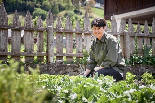a man sitting in front of a wooden fence at Kircherhof in Bressanone