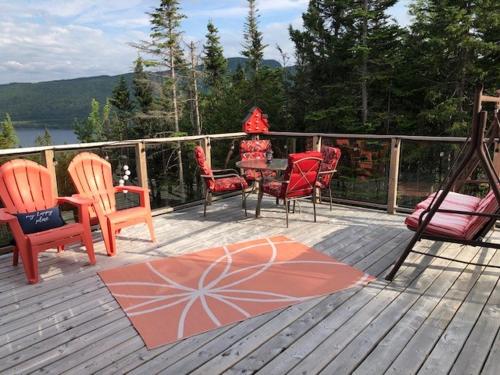 a deck with chairs and a table and a swing at The Thoughtful Dog Bed & Breakfast in South Brook