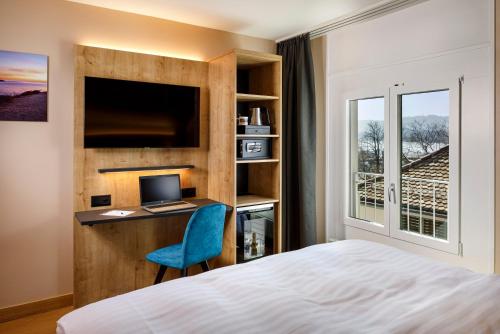 Schlafzimmer mit einem Bett und einem Schreibtisch mit einem Computer in der Unterkunft Hotel California in Zürich