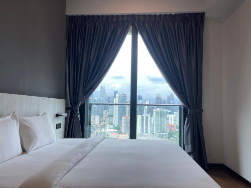 une chambre avec un lit et une grande fenêtre dans l'établissement Opus Residences Warisan Merdeka by C&C Fortune, à Kuala Lumpur