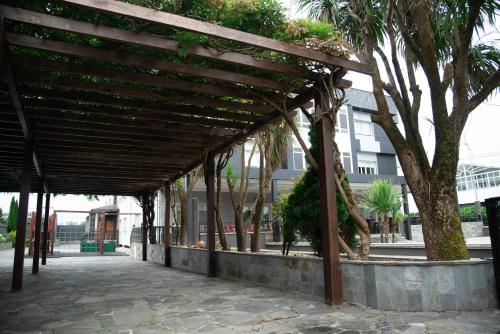 a wooden pergola on a sidewalk next to a building at Hotel Los Olmos in Lugo