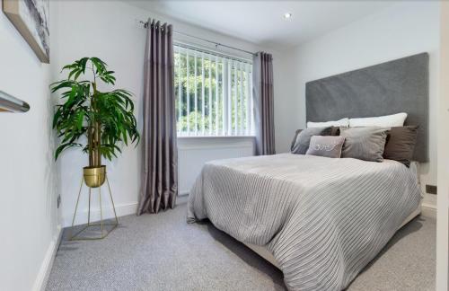 een slaapkamer met een groot bed en een potplant bij Inviting 2-Bed House in Newcastle upon Tyne in Newcastle upon Tyne