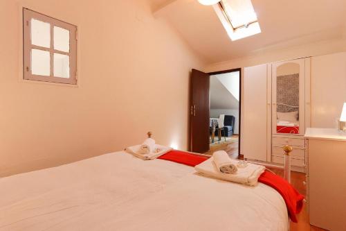 リスボンにあるBairro Alto Cosy by Homingのベッドルーム1室(大きな白いベッド1台、タオル付)