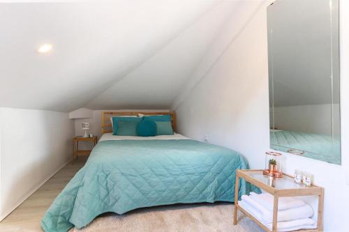 リスボンにあるBairro Alto Views by Homingのベッドルーム(青い枕と鏡付きのベッド1台付)