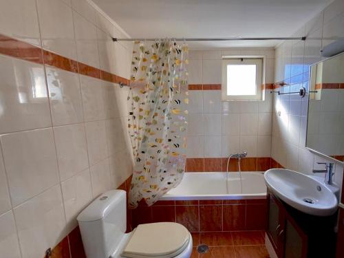 a bathroom with a toilet and a tub and a sink at Infinity view - Few steps away from the sea. in Agia Pelagia