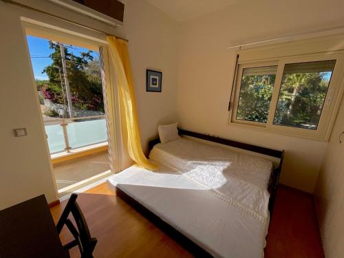 a small bedroom with a bed and a window at Infinity view - Few steps away from the sea. in Agia Pelagia