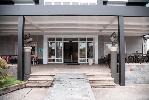 an entrance to a building with glass doors and tables at Hotel Los Olmos in Lugo