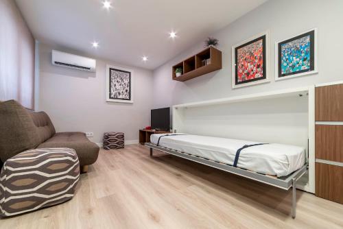 um quarto com uma cama e um sofá em MintyStay - Conde de Miranda em Madri