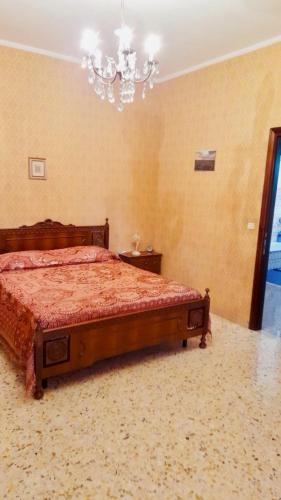 a bedroom with a bed and a chandelier at LE RADICI in Civitella dʼAgliano