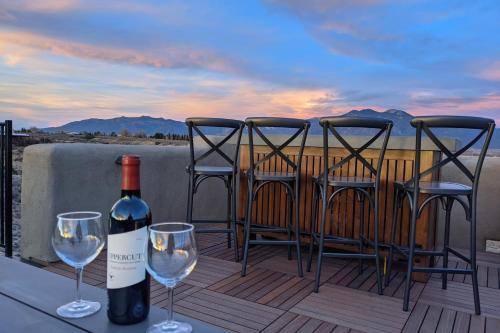 a bottle of wine sitting on a table with three chairs at Cottam Pines A in Taos