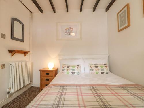 um quarto com uma cama branca e uma mesa de cabeceira em Hope Cottage em Bakewell