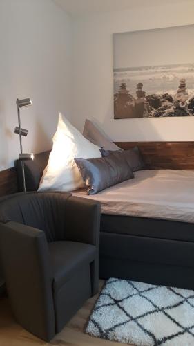 1 dormitorio con 1 cama con silla y 1 foto en Gemütliches Apartment am Kurpark in Bad Ems, en Bad Ems