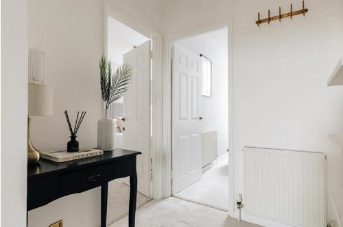 a hallway with a black desk and a white door at The Portland Apartment - Georgian Building with parking in Bath