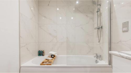 a white bathroom with a tub and a shower at The Portland Apartment - Georgian Building with parking in Bath
