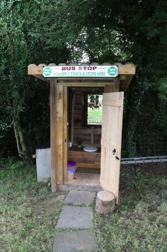 a wooden bus stop with a toilet in it at The Megabus near Tavistock and Dartmoor. in Lamerton