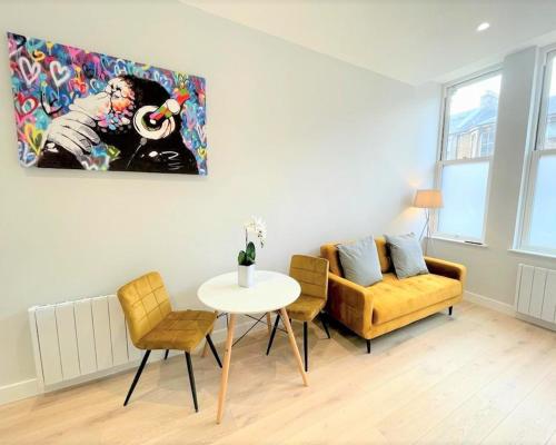 uma sala de estar com uma mesa e um sofá em Chic, Newly Reno'd 1 Bed Open Plan, nr The Meadows em Edimburgo