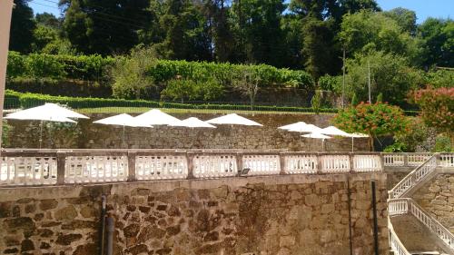 a stone wall with white umbrellas on a bridge at INATEL Palace S.Pedro Do Sul in Termas de Sao Pedro do Sul
