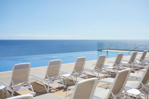 a row of chairs sitting on top of a swimming pool at Bahia Principe Fantasia Tenerife - All Inclusive in San Miguel de Abona