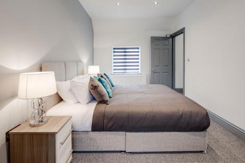 a bedroom with a large bed and a table with a lamp at Your Perfect Ashford Retreat Pet-Friendly & Business Ready in Ashford