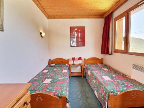 Zimmer mit 2 Betten, einem Tisch und einem Fenster in der Unterkunft Appartement Méribel, 2 pièces, 4 personnes - FR-1-182-17 in Méribel