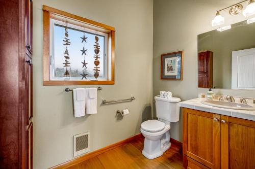 a bathroom with a toilet and a sink and a window at Escape to the Cape in Tillamook