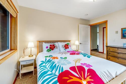 a bedroom with a bed with a floral bedspread at Escape to the Cape in Tillamook